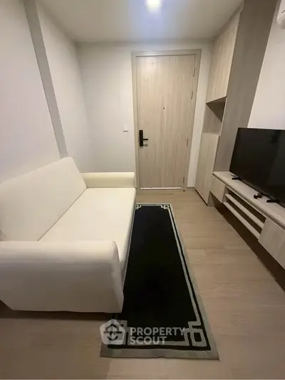 Cozy living room with modern sofa and TV setup, perfect for relaxation.
