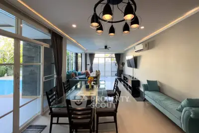 Spacious living room with pool view, modern furniture, and elegant lighting in a luxurious home.