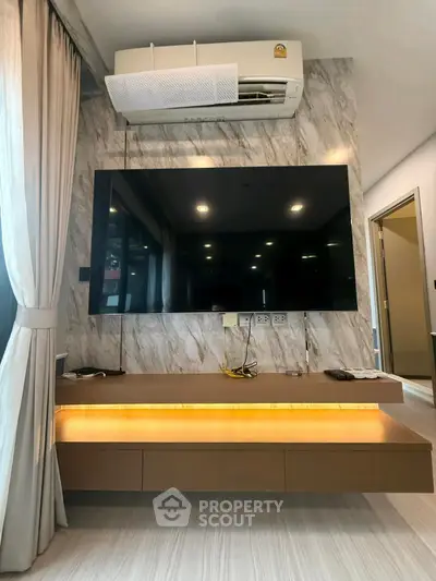 Modern living room with wall-mounted TV and air conditioning unit, featuring elegant marble wall design.