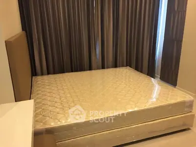 Spacious bedroom with large bed and elegant curtains in modern apartment.