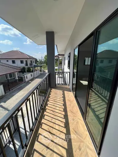 Spacious balcony with modern railing and scenic neighborhood view in a contemporary home.