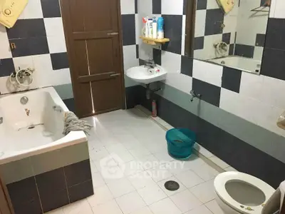 Spacious bathroom with bathtub and modern fixtures in a stylish tiled design.