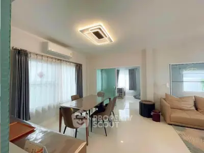 Modern living room with dining area and stylish lighting in open-concept apartment