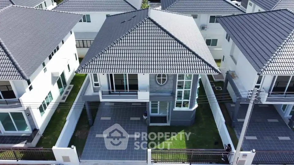 Modern two-story house with tiled roof and spacious driveway in a suburban neighborhood.