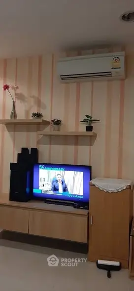 Cozy living room with modern air conditioning and stylish TV setup, perfect for relaxation and entertainment.