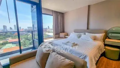 Luxurious bedroom with stunning city view and cozy seating area.