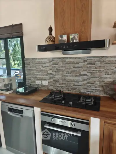 Modern kitchen with gas stove, oven, and stylish backsplash