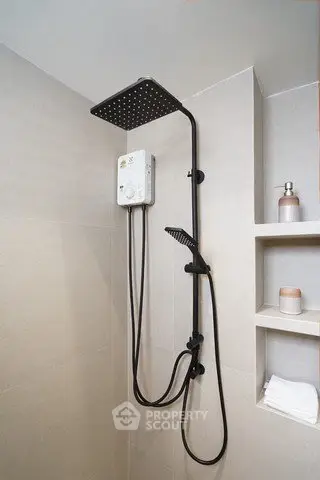 Modern bathroom with sleek showerhead and built-in shelving for a minimalist design.