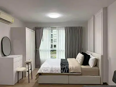 Spacious modern bedroom with elegant decor and large window view.