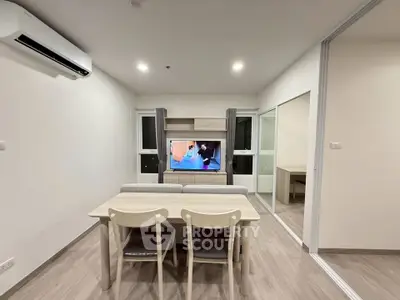 Modern living room with sleek furniture and wall-mounted TV in a cozy apartment.
