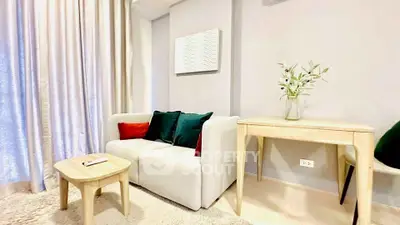 Chic living room with modern decor, cozy white sofa, and elegant wooden furniture in a bright, inviting space.
