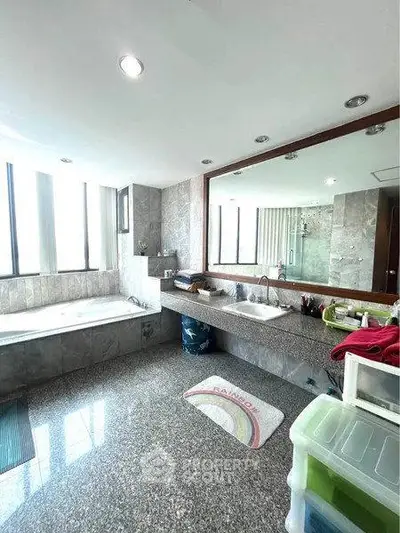 Spacious bathroom with large mirror and bathtub in modern apartment