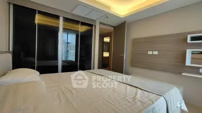 Modern bedroom with sleek design and mirrored closet doors in a contemporary apartment.