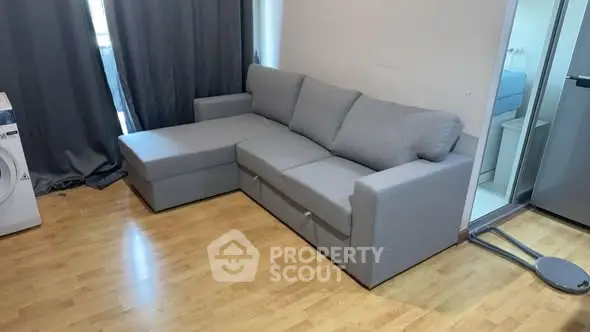 Modern living room with gray sectional sofa and wooden flooring