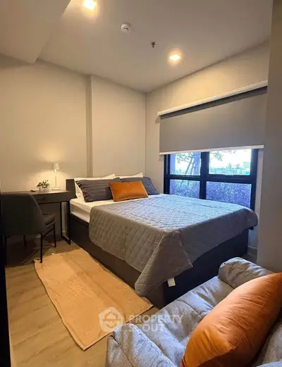 Cozy bedroom with modern decor, featuring a comfortable bed, stylish desk, and large window for natural light.