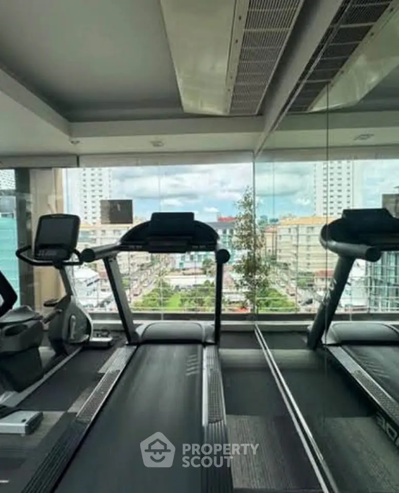 Modern gym with treadmills and city view, perfect for fitness enthusiasts seeking convenience and style.