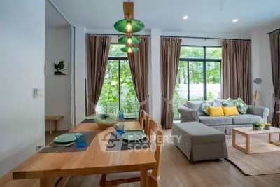 Spacious living room with modern decor and large windows offering garden views.
