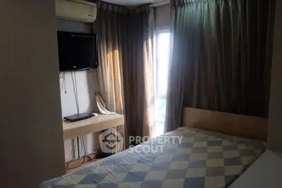 Cozy bedroom with natural light and modern amenities in a stylish apartment.