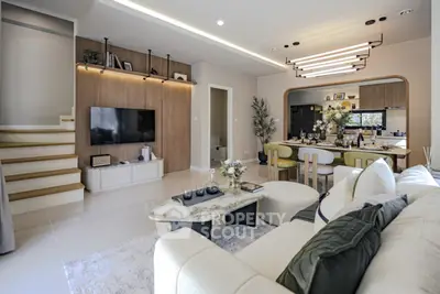 Luxurious modern living room with elegant decor and open dining area, perfect for entertaining guests.