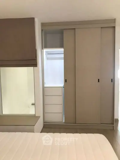 Modern bedroom with built-in wardrobe and cozy window seat, perfect for urban living.