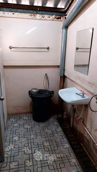 Compact bathroom with basic fixtures and vintage flooring