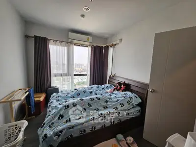 Cozy bedroom with large window offering city view, featuring modern decor and ample natural light.