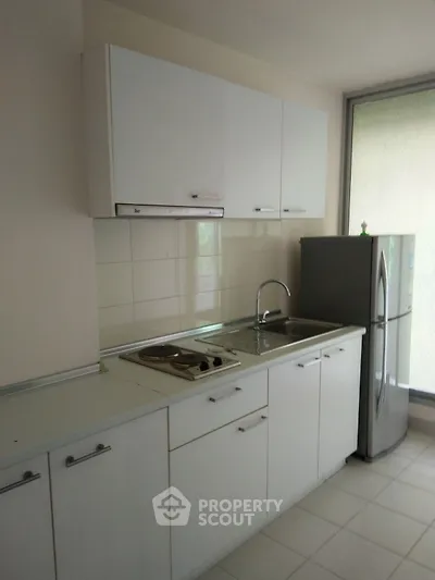 Modern kitchen with sleek white cabinetry and stainless steel appliances.