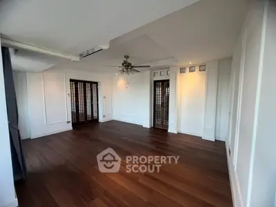 Spacious living room with elegant wooden flooring and ceiling fan