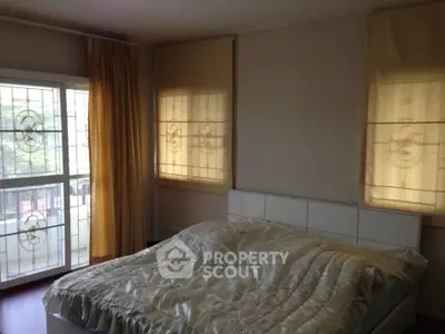 Cozy bedroom with large windows and soft lighting, perfect for relaxation.