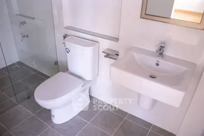 Modern bathroom with sleek fixtures and glass shower enclosure.