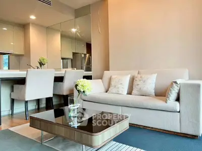 Modern living room with elegant decor and open kitchen layout, featuring a cozy sofa and stylish dining area.