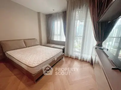 Modern bedroom with large windows and city view, featuring a comfortable bed and stylish decor.