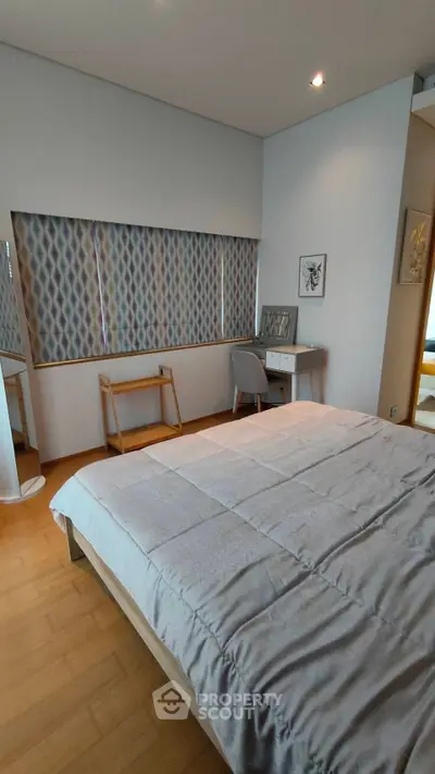 Cozy bedroom with modern decor and natural light, featuring a comfortable bed and stylish furnishings.