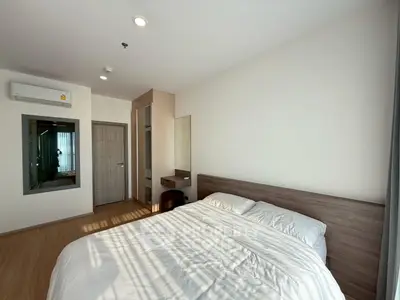 Modern bedroom with wooden flooring and natural light