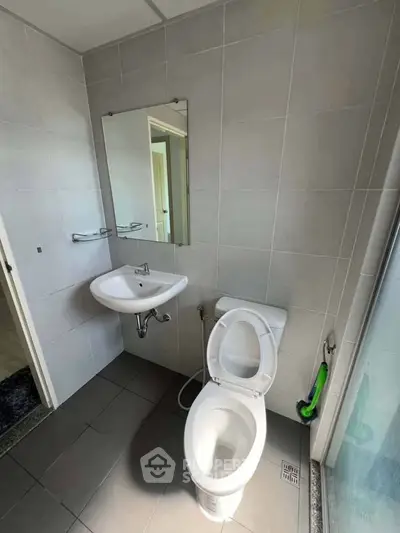 Modern bathroom with sleek fixtures and large mirror in a contemporary home.