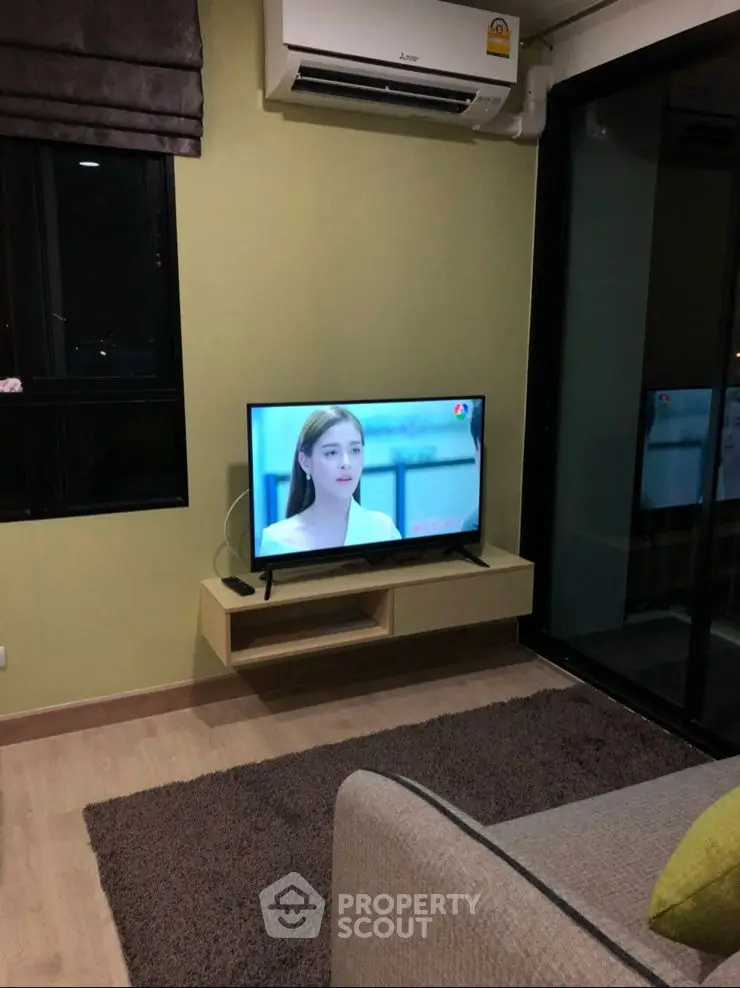 Cozy living room with TV and air conditioning, featuring a modern design and comfortable ambiance.