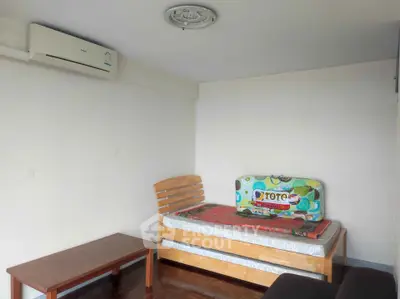Cozy bedroom with single bed, air conditioning, and wooden furniture, perfect for a minimalist lifestyle.