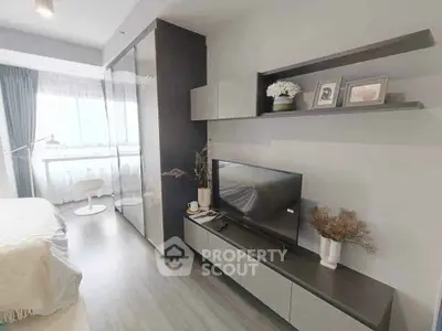 Modern living room with sleek TV unit and large window, offering a bright and airy ambiance.