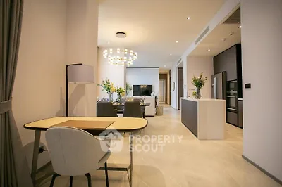 Modern open-plan living and dining area with elegant decor and contemporary lighting.
