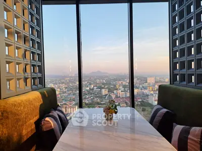 Stunning high-rise view from luxurious dining area with panoramic cityscape.