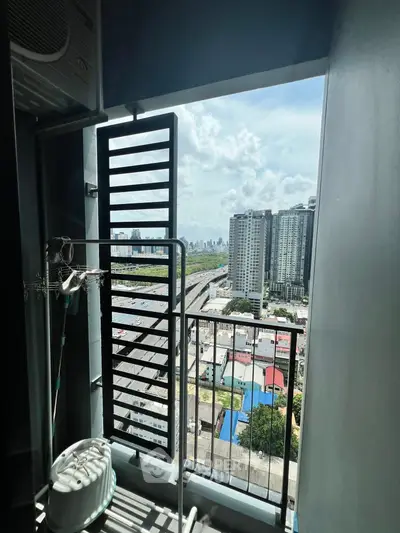 High-rise apartment balcony with stunning cityscape view and modern railing.