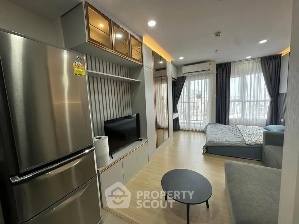 Modern studio apartment with sleek design, featuring a cozy living area, stylish kitchen, and large windows for natural light.