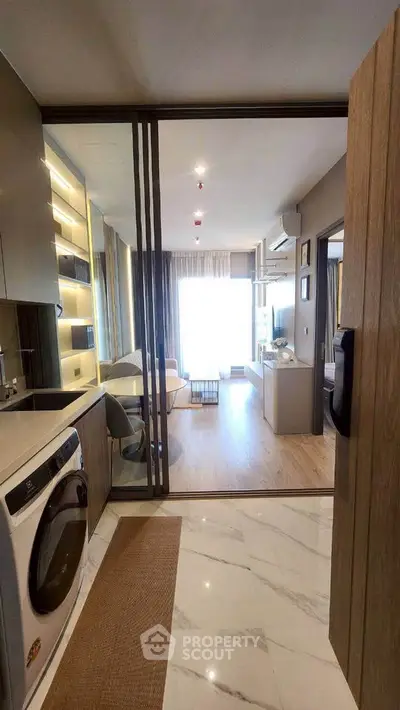 Modern apartment interior with open layout, featuring a sleek kitchen and spacious living area with natural light.