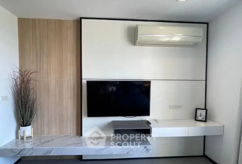 Modern living room with sleek TV setup and air conditioning unit