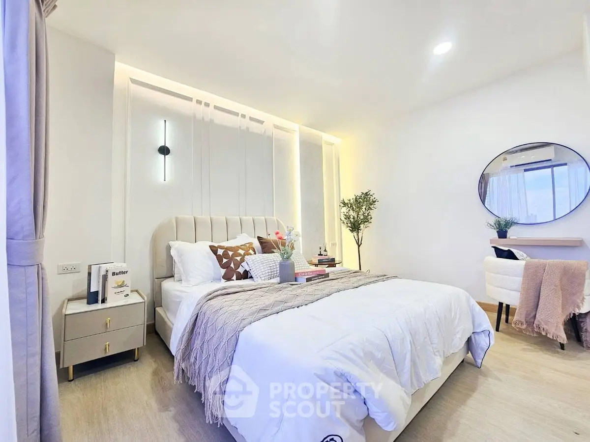 Modern bedroom with stylish decor, featuring a cozy bed, elegant lighting, and a chic mirror for a serene ambiance.
