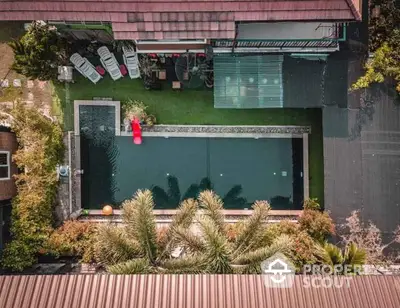 Stunning aerial view of a luxurious private pool surrounded by lush greenery and modern amenities.