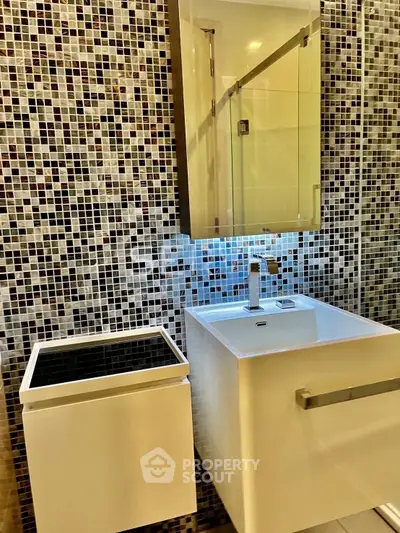 Modern bathroom with stylish mosaic tiles and sleek vanity unit.