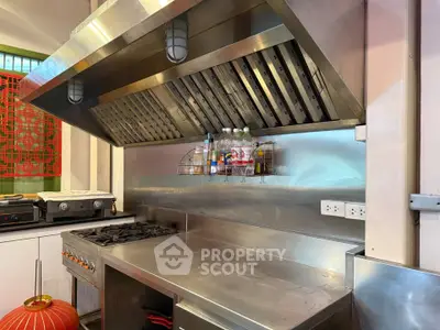 Modern kitchen with stainless steel appliances and gas stove, featuring sleek design and ample counter space.