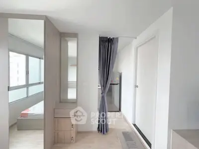 Modern apartment interior with bedroom and kitchen, featuring sleek design and natural light.
