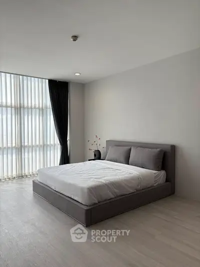 Spacious modern bedroom with large window and elegant decor